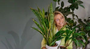 Julia Feldmann, Markenstrategin aus Nürnberg, posiert mit einer Topfpflanze.